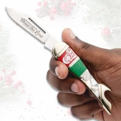 Hand holding a Christmas-themed knife with religious motif