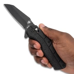 Hand holding a black folding knife with textured grip
