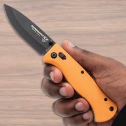 Hand holding an orange-handled pocket knife