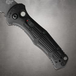 Close-up of black knife handle with textured grip and button