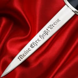 Blade of dagger with engraved text on red fabric
