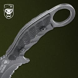 Close-up of knife handle with finger ring on green background