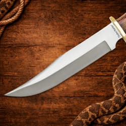 Close-up of Bowie knife blade on wooden background