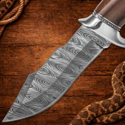 Close-up of patterned knife blade on wood background