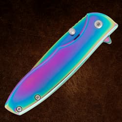 Closed rainbow-finish folding knife on brown background