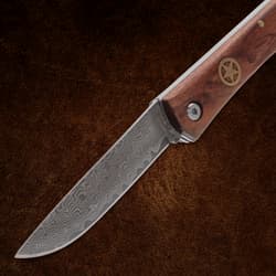 Folding knife with detailed patterned blade and wooden handle