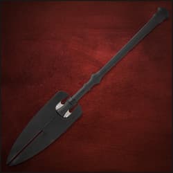 Spear with black sheath covering blades on red background