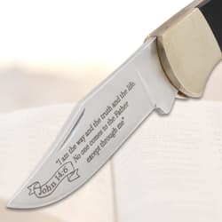 Close-up of engraved knife blade on open book