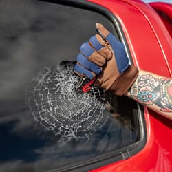 Gloved hand using Ridge Runner knife to break car window
