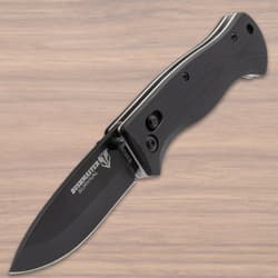 Open black folding knife with textured handle on wood background