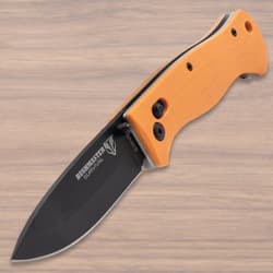 Open pocket knife with orange handle on wood