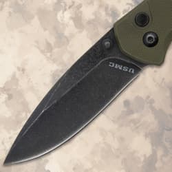 Close-up of the black blade of a USMC folding knife