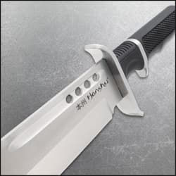 Close-up of knife blade with engraved text and black handle