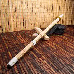 Bamboo shinai sword on wooden floor with bamboo wall backdrop