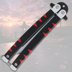 Closed butterfly knife with black and red handle, cherry blossom background