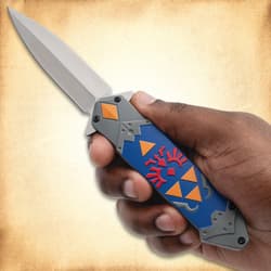 Hand holding a decorative knife with blue and orange design