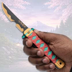 Hand holding a decorative knife with red and teal handle