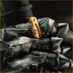 Gold ring with glowing inscription on armored hand