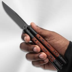 Hand holding a butterfly knife with wood handle