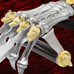 Side view of claw weapon showing wolf head details on blades