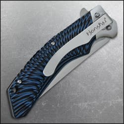 Closed pocket knife with large pocket clip inscribed with "honshu" and a tiedye style blue and black handle.