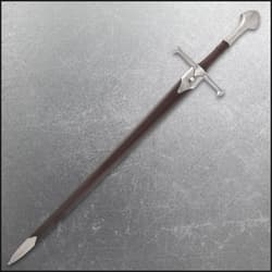 Sword sheathed in brown scabbard on textured surface