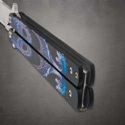 Close-up of butterfly knife handles with dragon design
