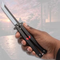 Hand holding black butterfly knife with cherry blossom backdrop