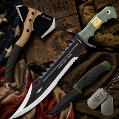 USMC-themed knives and axe on wooden background