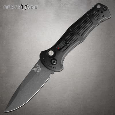 Black folding knife with textured handle on gray background