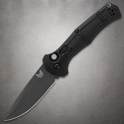 Black folding knife with textured handle on gray background
