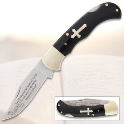 Folding knife with cross inlay and engraved blade on open book