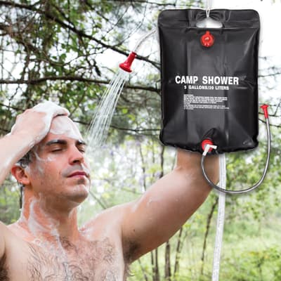 Man using a camp shower in the outdoors