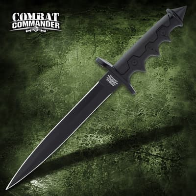 Black dagger with a textured grip on a green surface