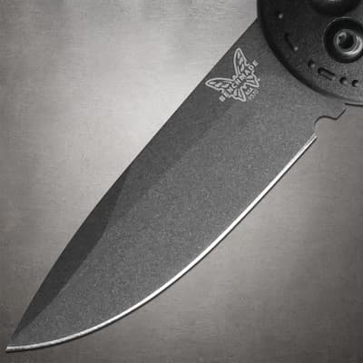Close-up of black knife blade with logo on gray background