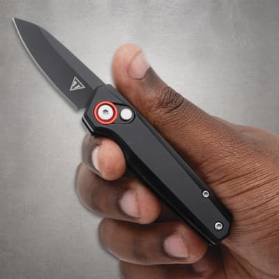 Hand holding a black folding knife