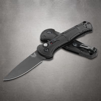 Partially open black folding knife with clip on gray surface
