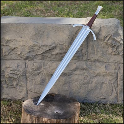 Knight sword embedded in a tree stump against a stone wall