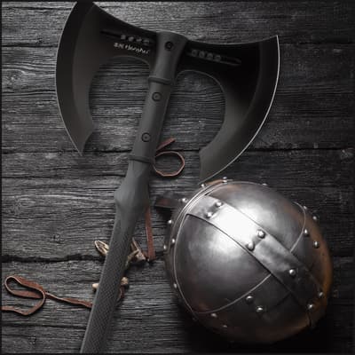 Black axe and metal helmet on wooden surface
