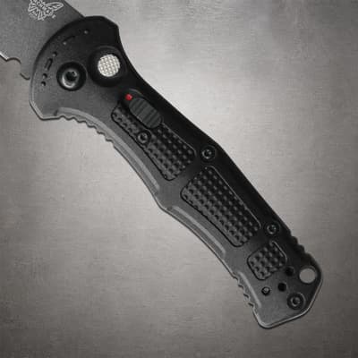 Close-up of black knife handle with textured grip and button