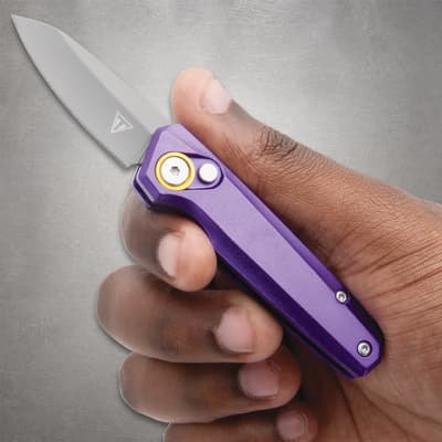 Hand holding a purple folding knife