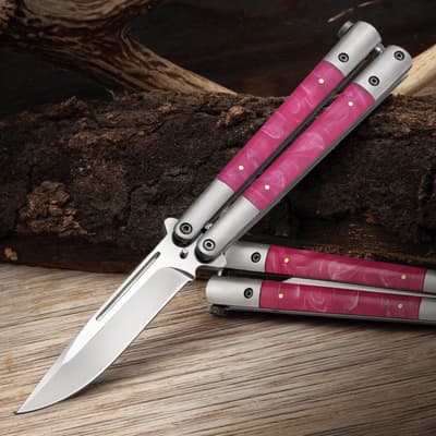 Butterfly knife with pink marble handle on wooden surface