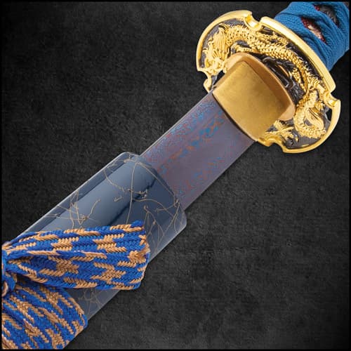 A 28 inch blue damascus steel blade with matching cord enclosed in a blue lacquered sheath with gold accents