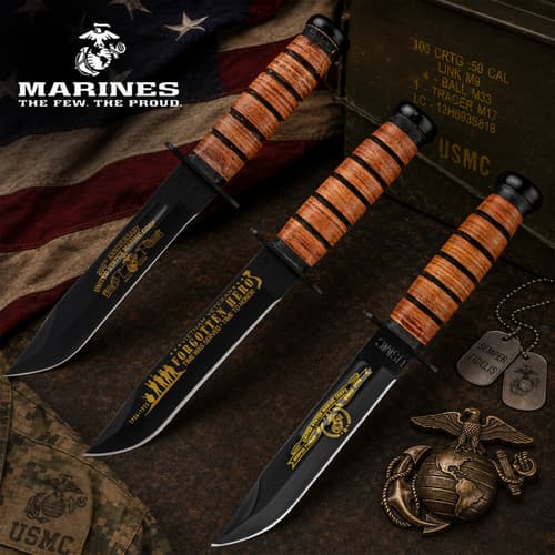 Three USMC knives with engraved blades on a flag background