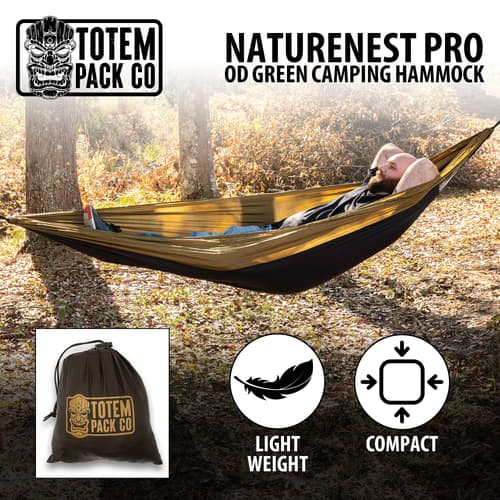 Full image of a person laying in the Totem Pack Co. NatureNest Pro OD Green Camping Hammock.