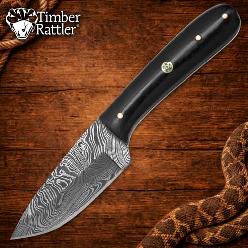 Damascus knife with black handle on wooden background