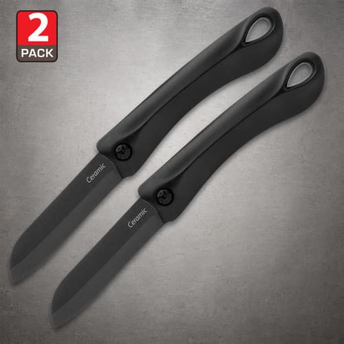 Two open black ceramic pocket knives with curved handles and ringed pommels on a gray background