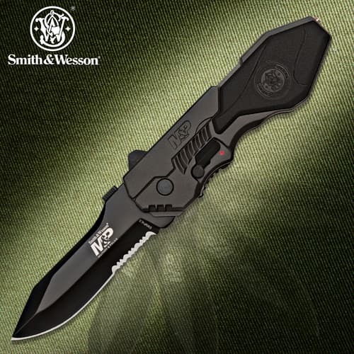 Black tactical knife with serrated blade on textured background