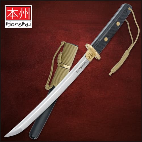 Tactical tanto with black handle and gold accents on red background