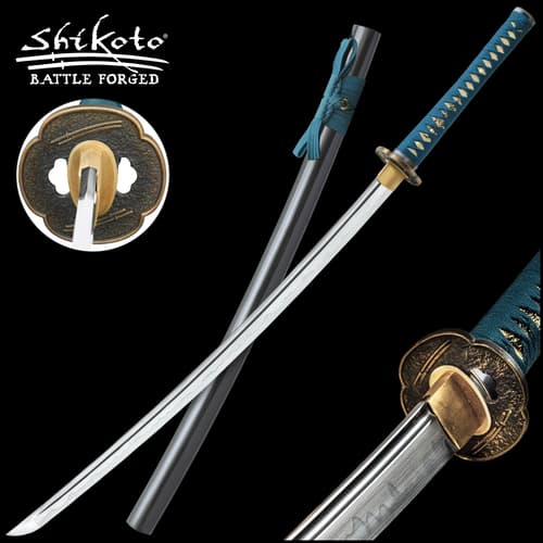 Katana handle wrapped in a teal cord and ray skin with a brass tsuba etched with double swords lying on a black scabbard